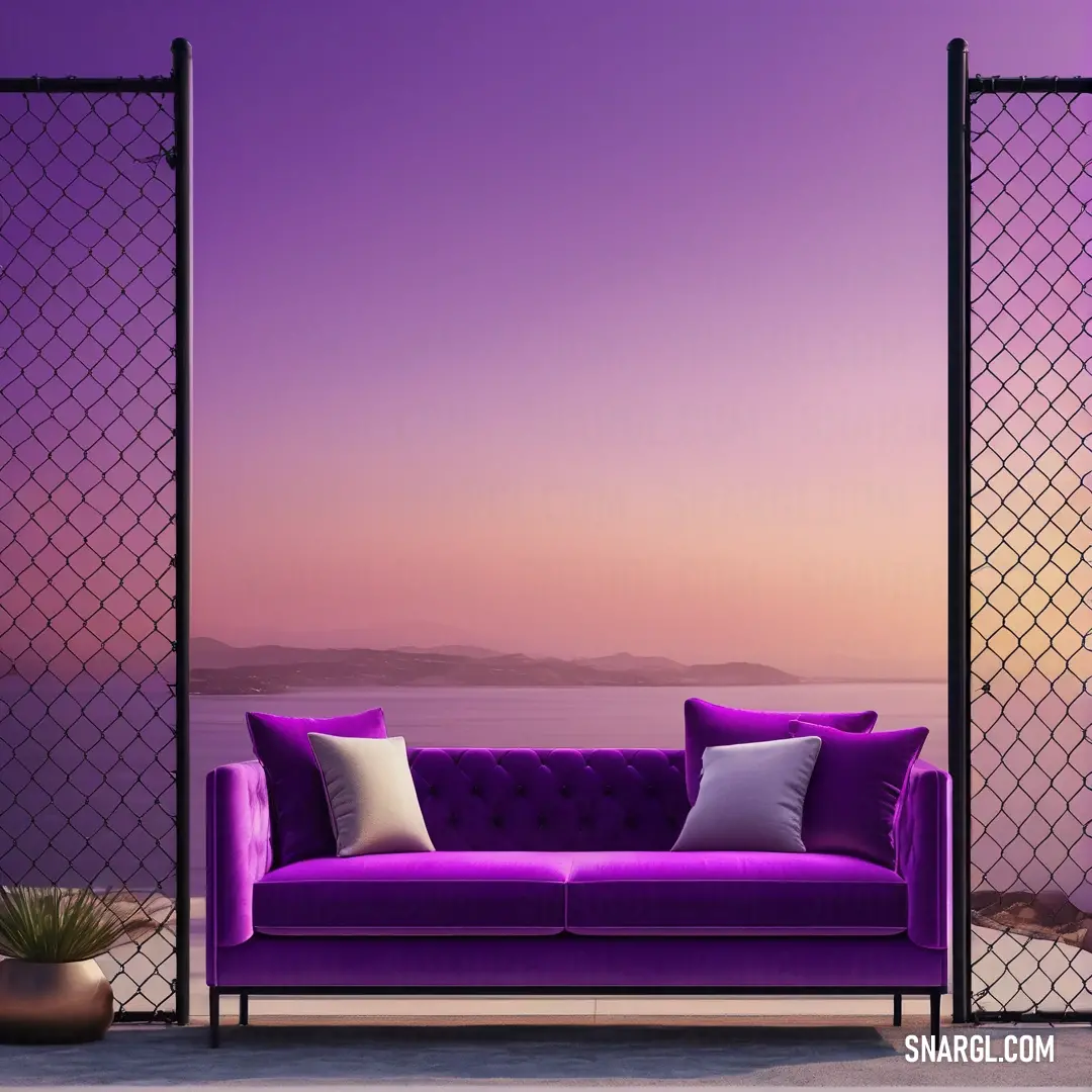 Purple couch next to a tall metal fence with a purple sky in the background. Color CMYK 0,100,0,45.