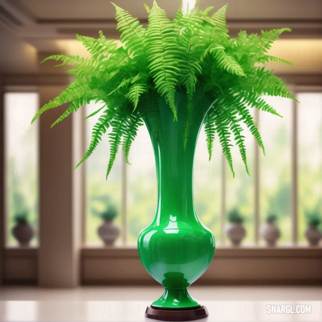 Green vase with a fern in it on a table in front of a window with a view of a room. Color Dark pastel green.