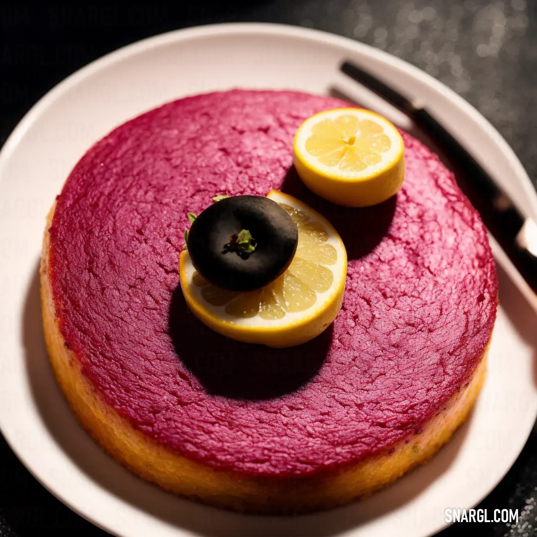Cake with a lemon slice and a black olive on top of it on a plate with a fork. Example of CMYK 0,64,45,9 color.