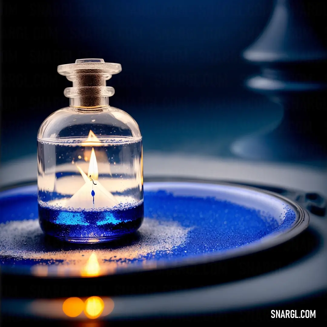 Candle is lit inside of a glass bottle on a plate with a blue background