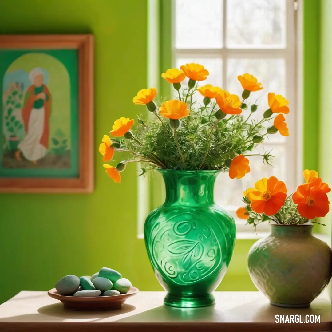 Green vase with yellow flowers and rocks on a table in front of a window with green walls and a picture of a virgin