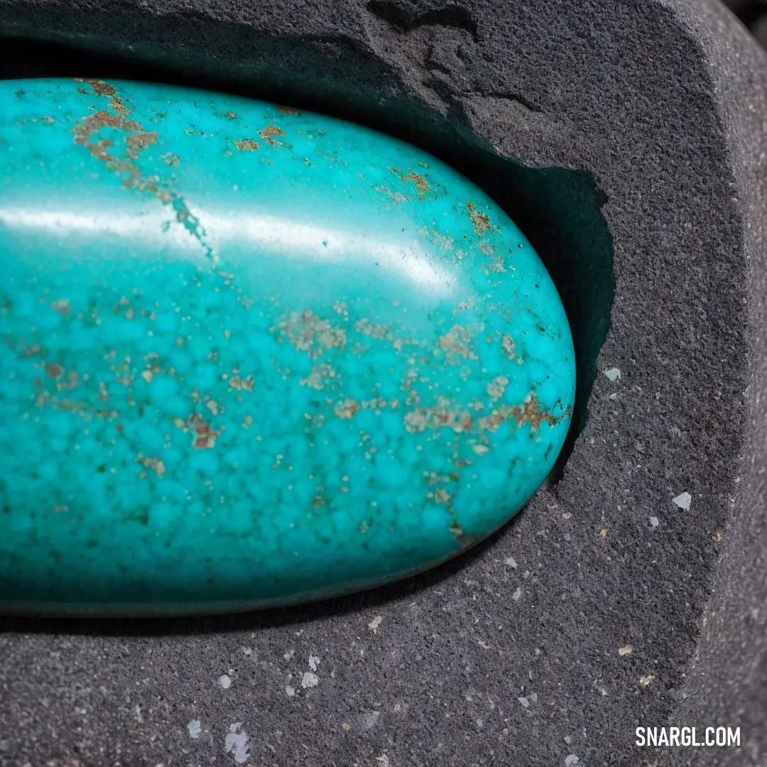 Dark turquoise color. Turquoise stone on top of a black object with rust on it's sides and a hole in the middle