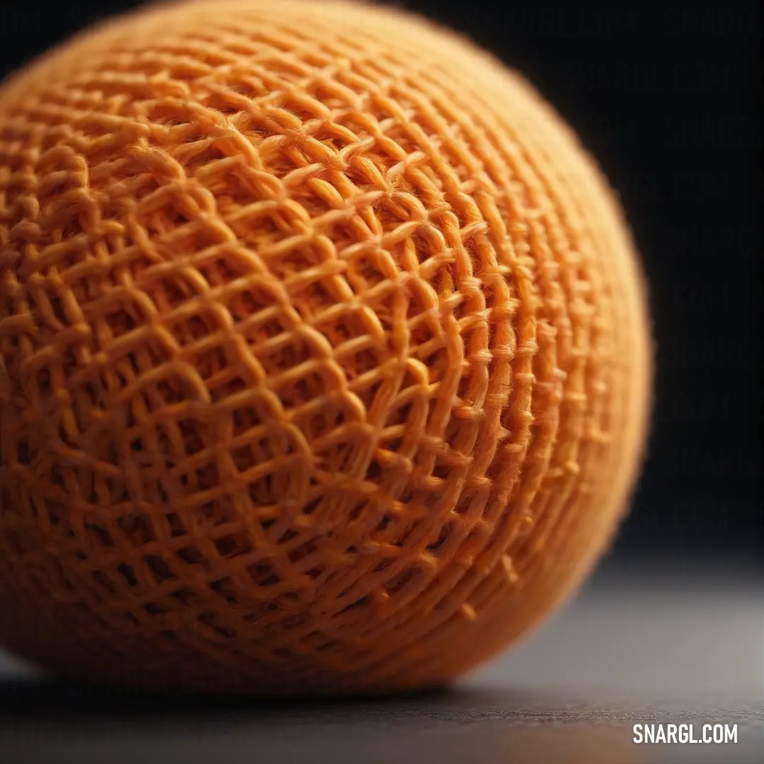 A close-up of a vibrant orange resting on a table, surrounded by darkness. The fruit’s smooth skin glows in the dim light, with rich hues of deep carrot orange standing out against the black backdrop.