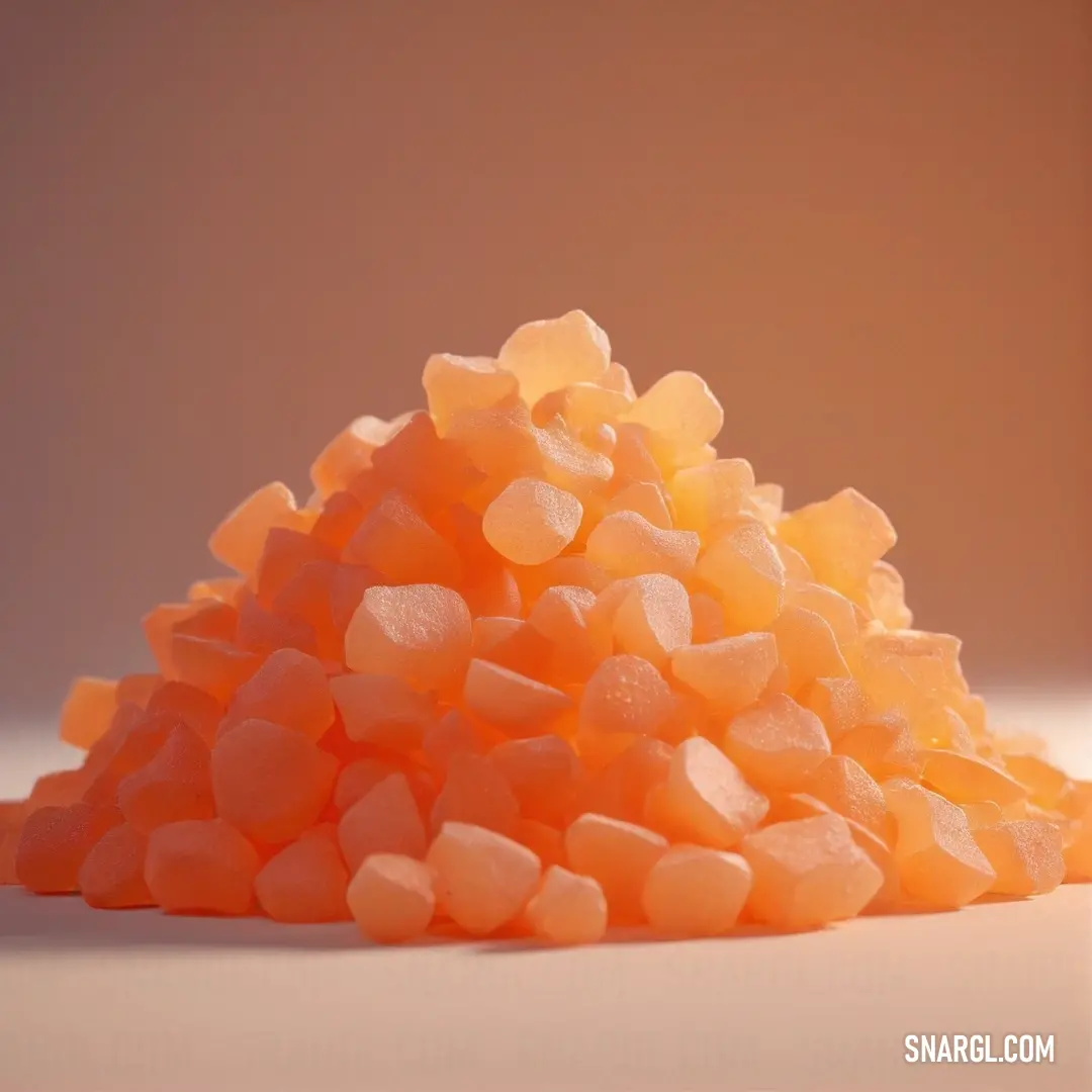 A vibrant pile of orange candy corn rests on a white surface, the bright orange color contrasting against the clean background. The candy’s playful appearance evokes a sense of fun and nostalgia.