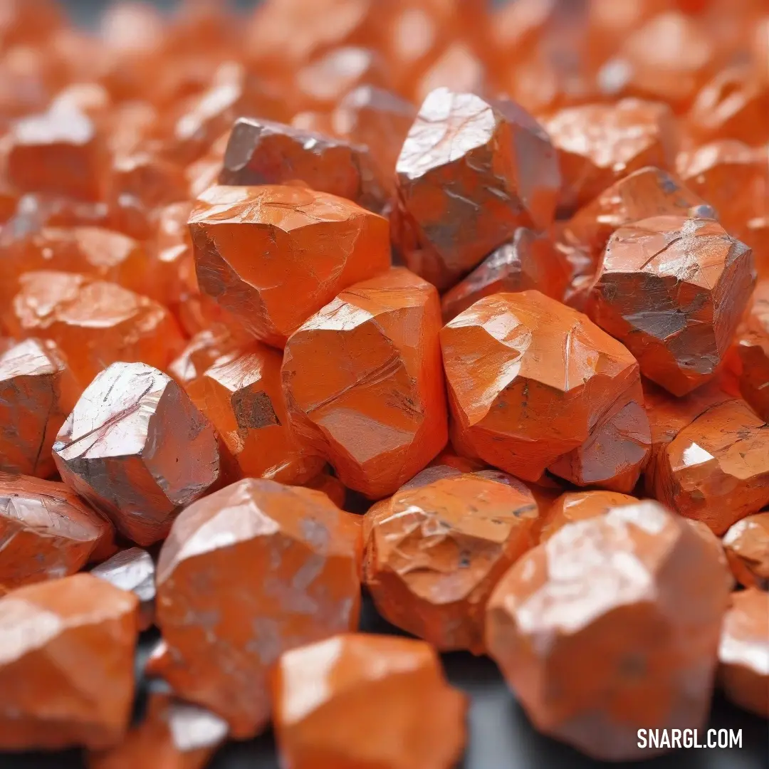 A collection of vibrant orange rocks stacked on a sleek black tabletop, offering a visual representation of the deep, rich hue of carrot orange, providing a bold contrast against the dark surface beneath them.