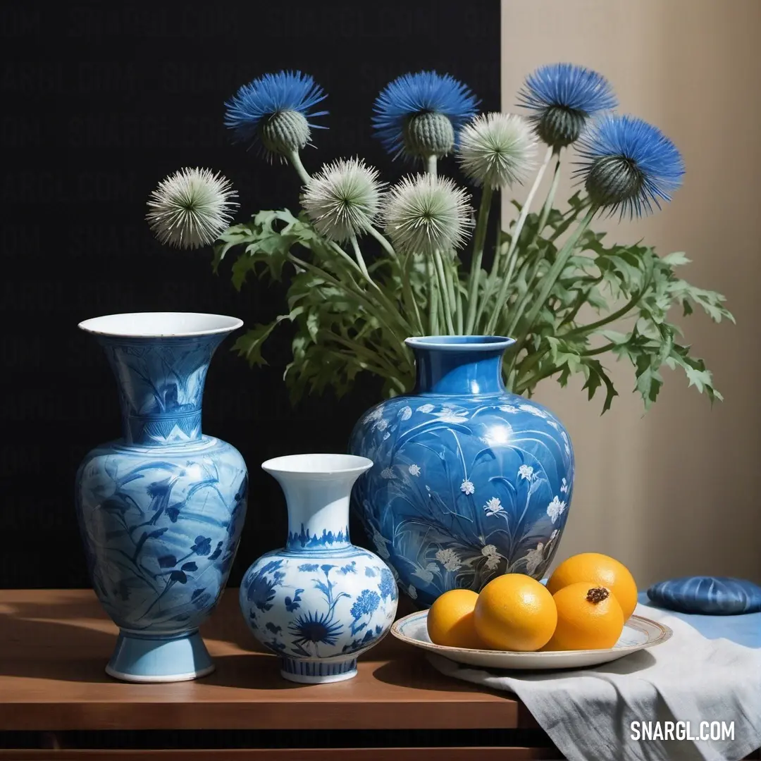 Denim color. Table with a plate of fruit and vases on it and a vase with flowers in it on a table