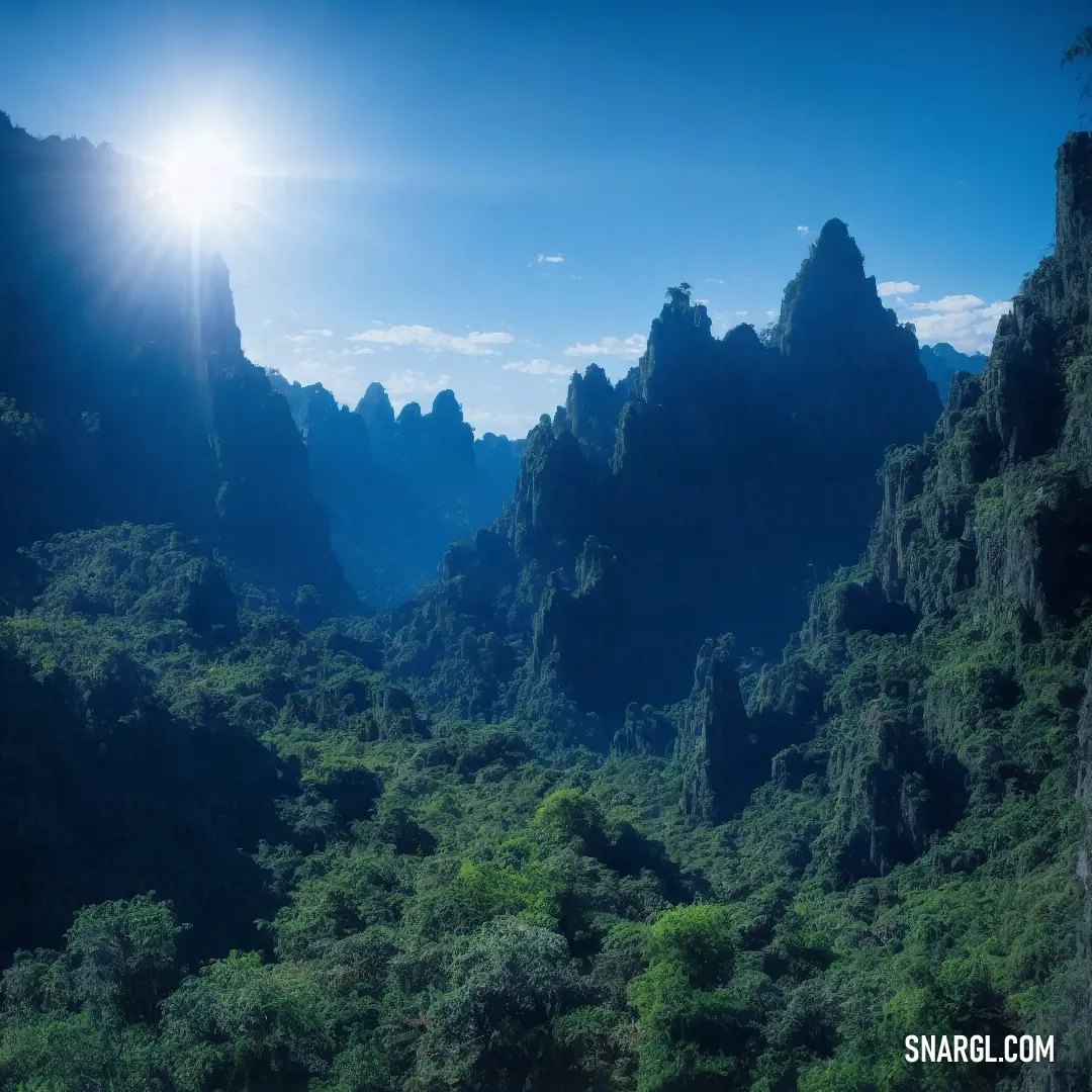 Mountain range with a bright sun in the background and a blue sky above it