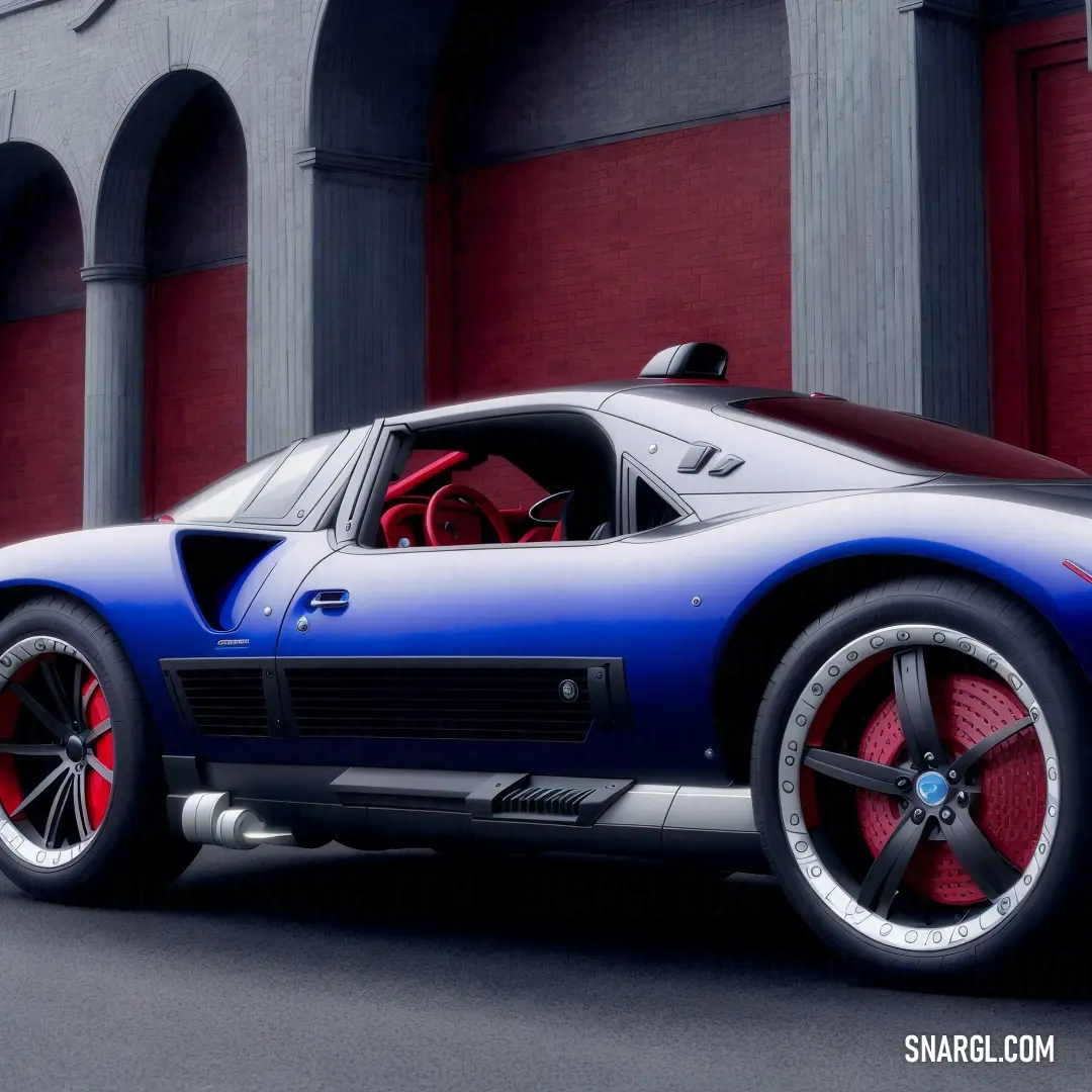Blue sports car parked in front of a building with red tires and rims on it's tires