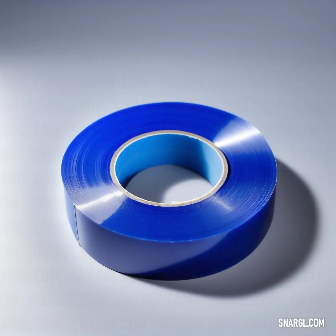 Blue tape is on a white surface with a shadow on it and a shadow on the floor behind it. Color RGB 0,0,156.
