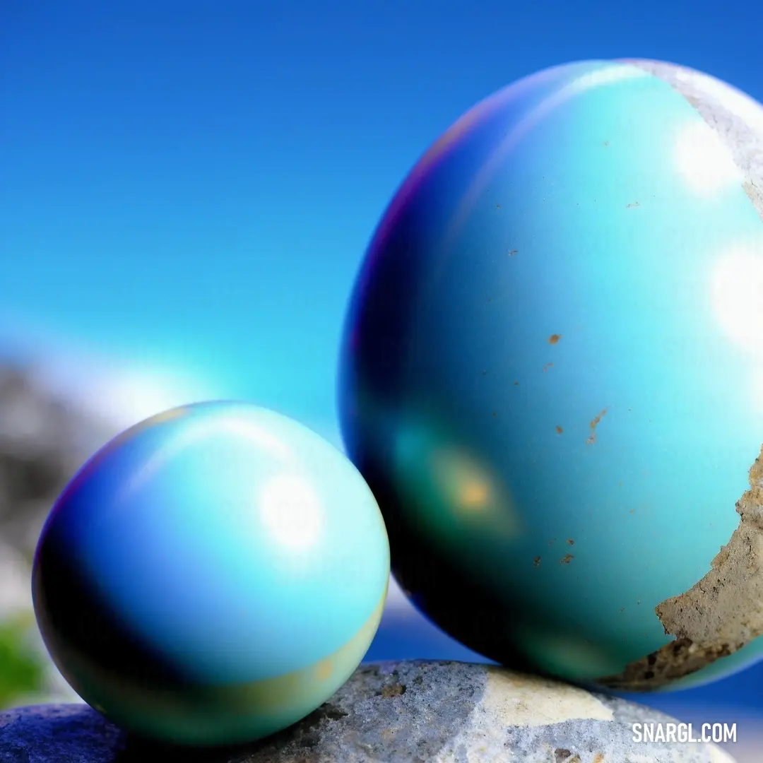 Two blue eggs on top of a rock next to each other on a sunny day with a blue sky in the background