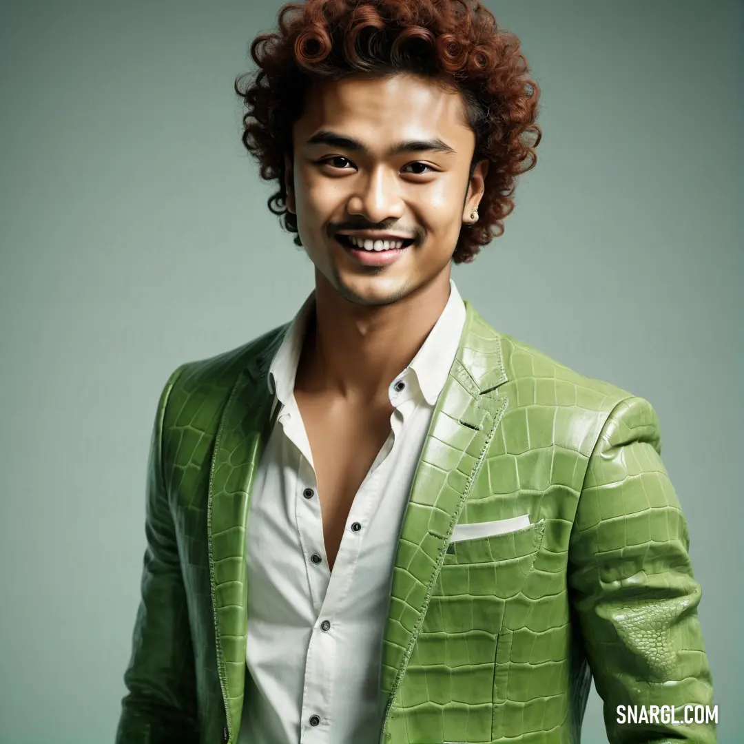Man with curly hair wearing a green jacket and white shirt and smiling at the camera