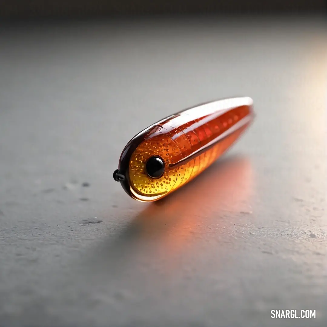 Fire Brick color example: Close up of a small orange object on a table top with a light shining on it