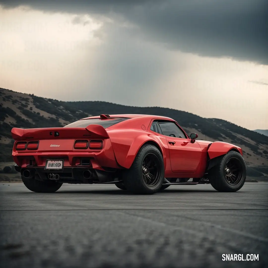 Red sports car parked on a road under a cloudy sky with mountains in the background. Color Fire Brick.