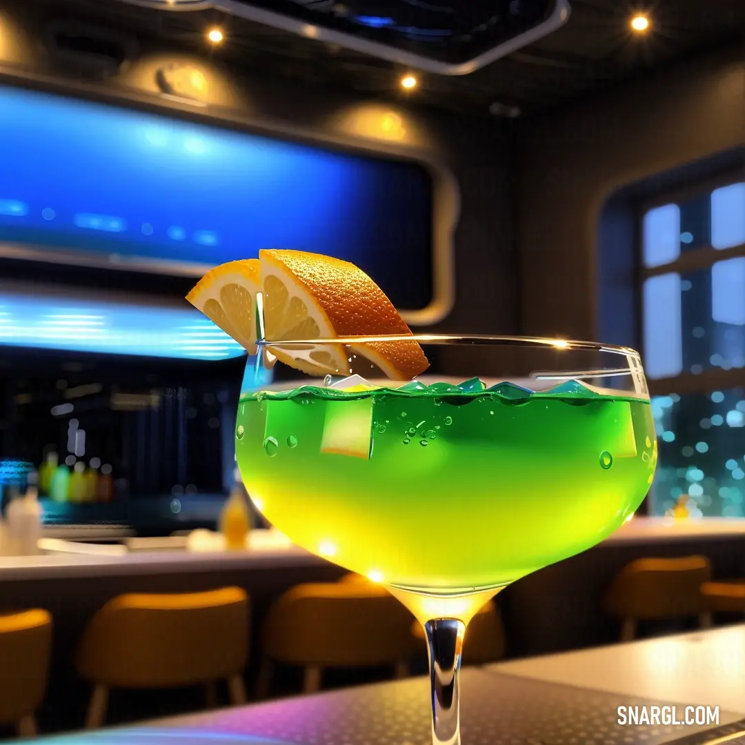 Green drink with a slice of lemon on the rim of it on a bar top with a television in the background
