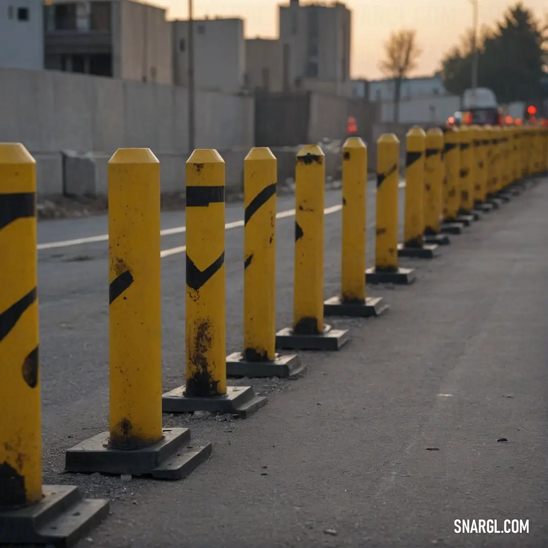 A vibrant row of yellow barriers lines the side of a road, their bold hue and geometric design catching the eye. They stand sturdy and alert, marking boundaries and adding a bright splash of color to the urban landscape.