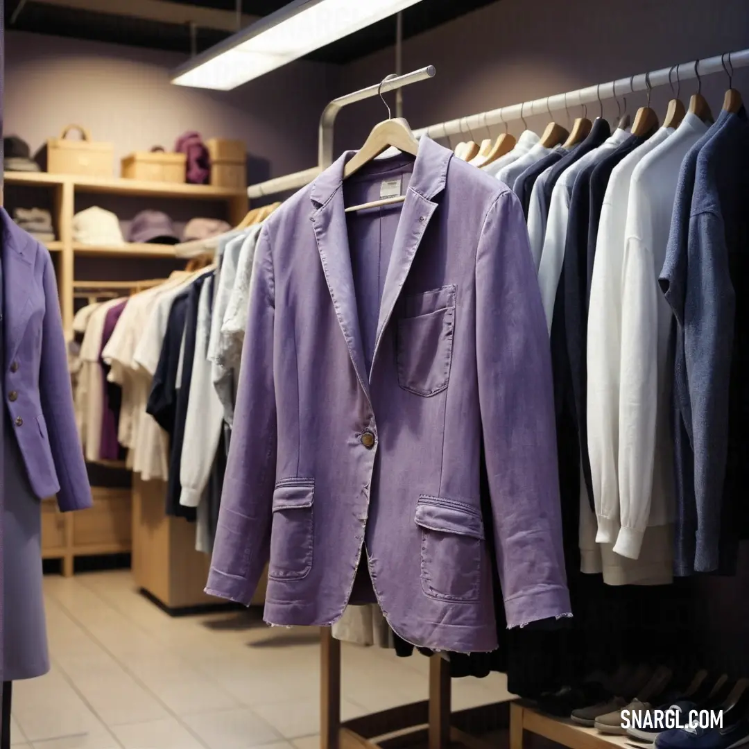 Rack of clothes in a store with a purple jacket hanging on a rail and a white shirt hanging on a rack. Color #86608E.