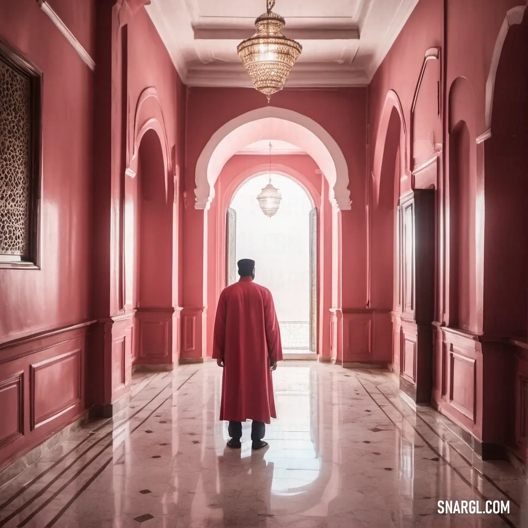 Man in a red robe is standing in a hallway with a chandelier hanging from the ceiling. Example of Fuzzy Wuzzy color.