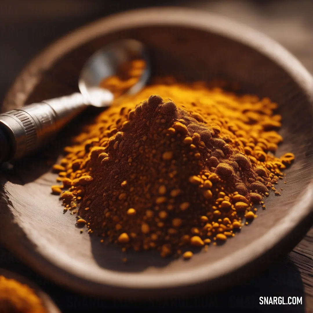 Wooden bowl filled with yellow powder and a spoon on a table next to it. Example of Ginger color.