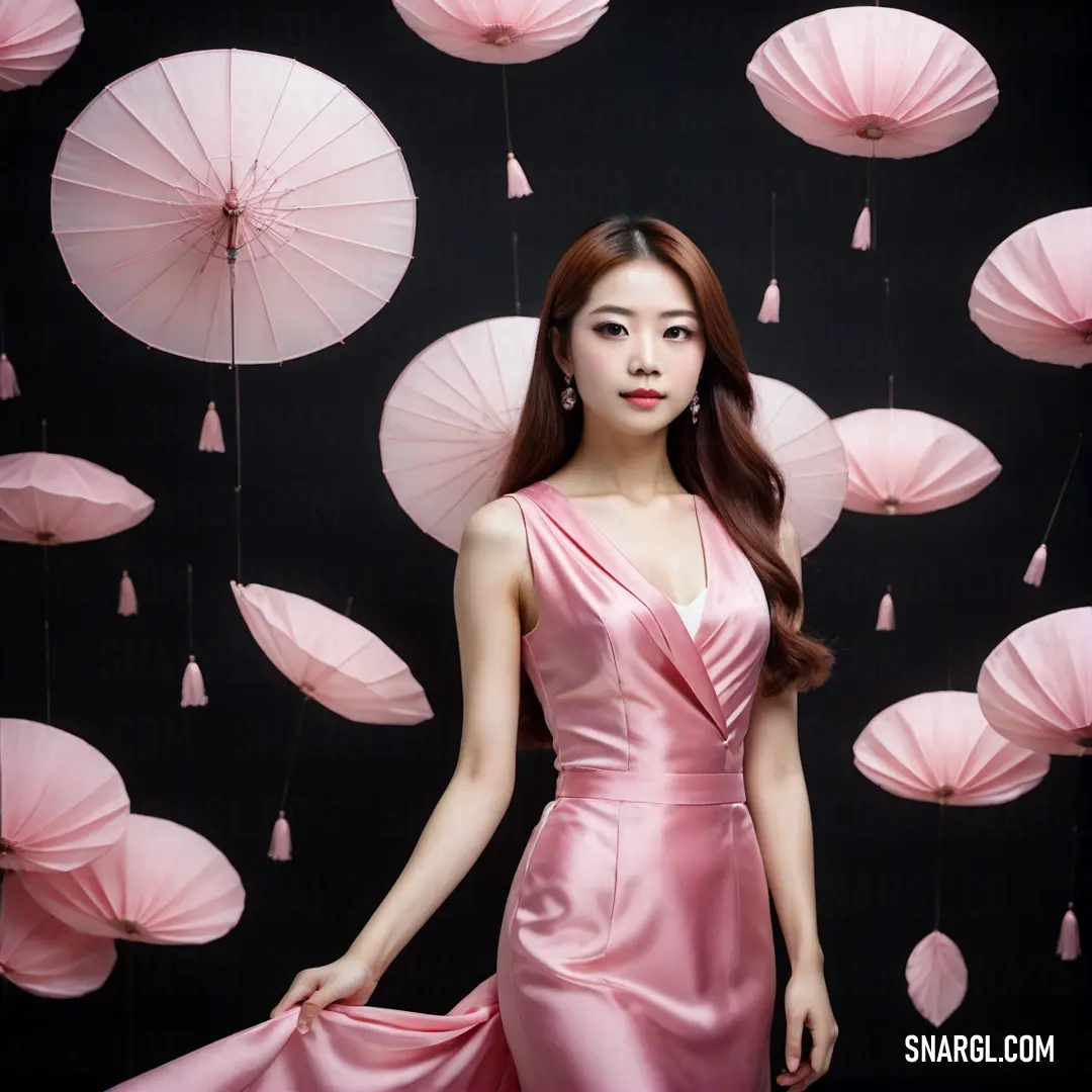 Woman in a pink dress standing in front of pink umbrellas in a room