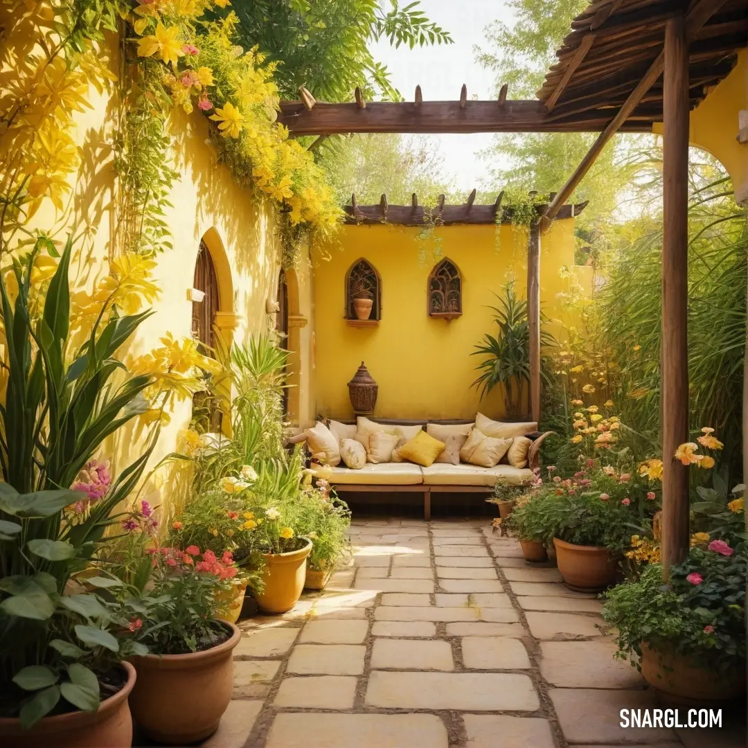 A cozy patio adorned with a comfortable couch, potted plants, and a vibrant yellow wall behind. Large windows and a bench complete the inviting space, offering a peaceful spot to relax and enjoy the warm goldenrod tones.