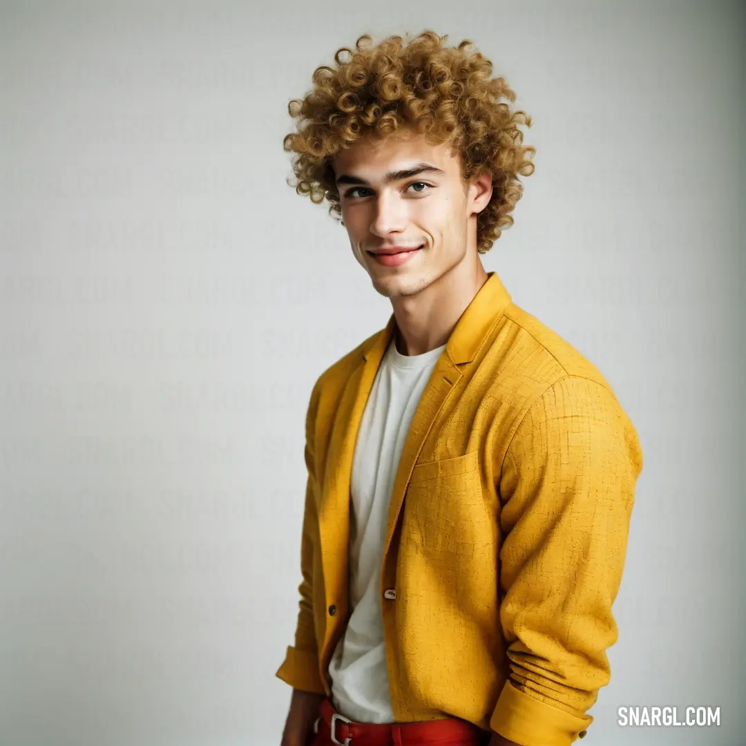 Man with curly hair is smiling for a picture in a yellow jacket and red pants and a white shirt. Example of CMYK 0,24,85,15 color.