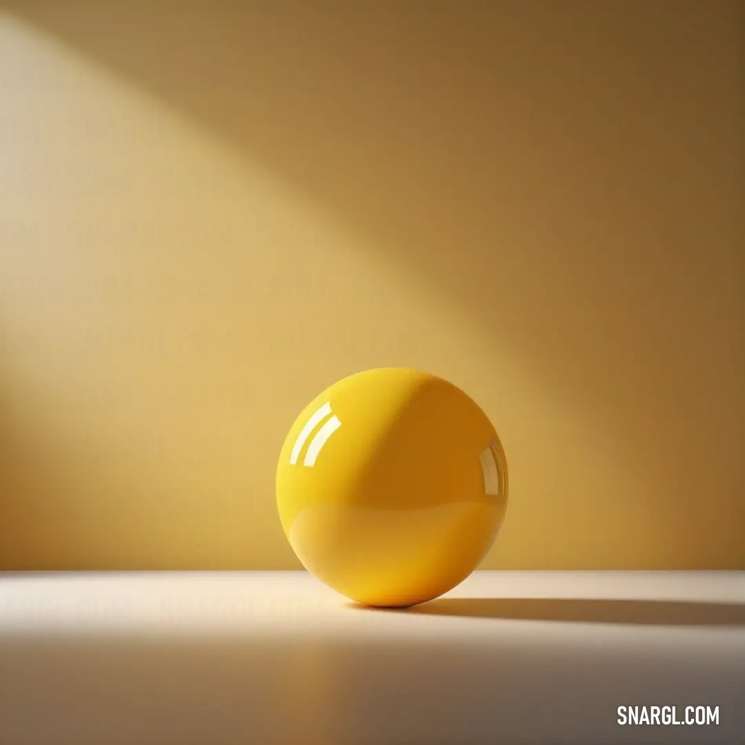 Yellow ball on a white table in the sunlight with a shadow on the wall behind it. Color #DAA520.