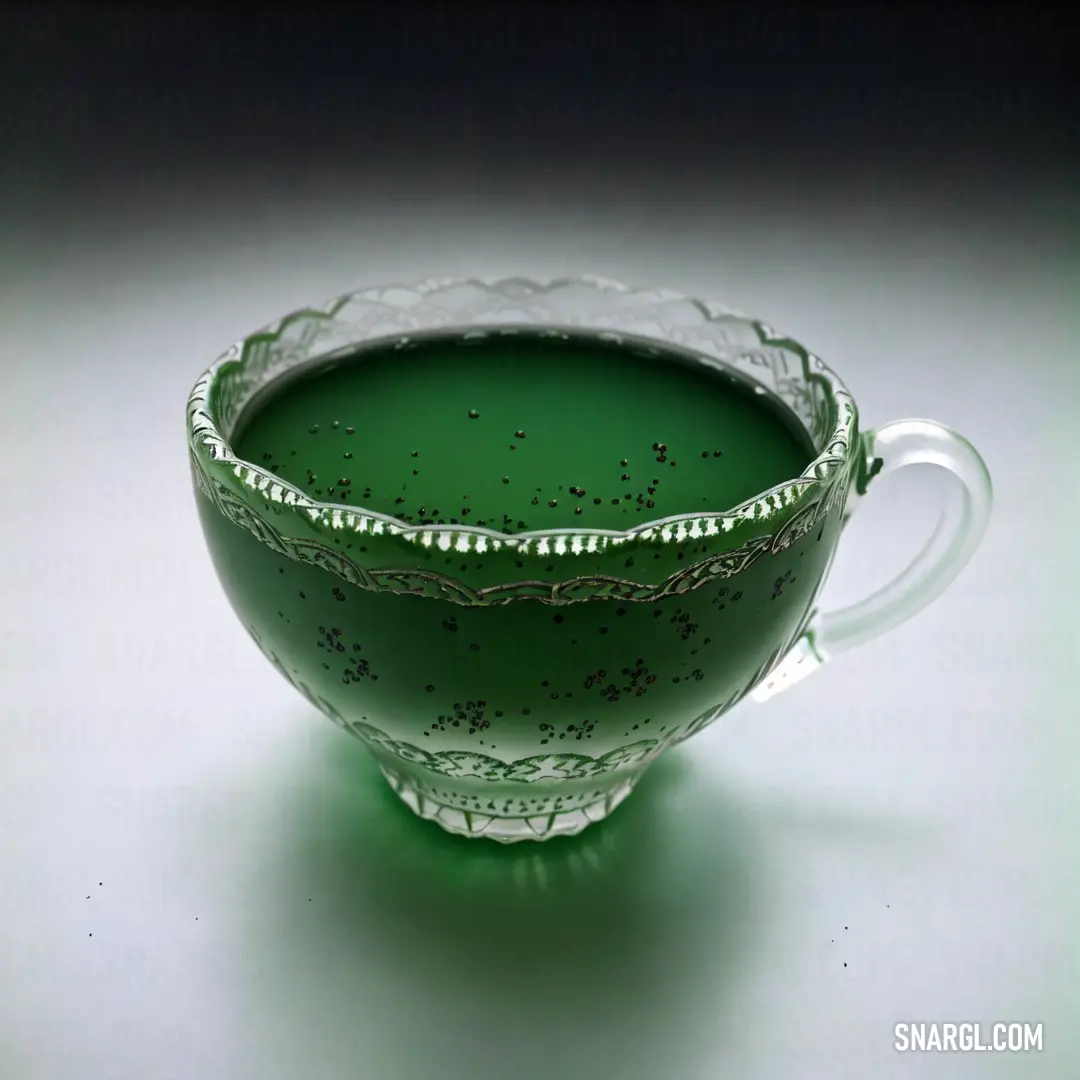 Green glass bowl with a handle on a white table top with a black background