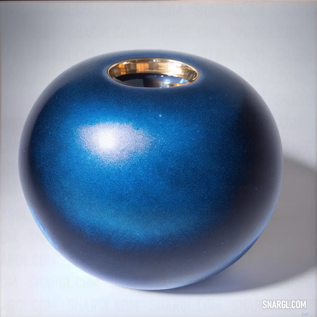 Blue vase with a gold ring on it's side on a white surface with a light reflection