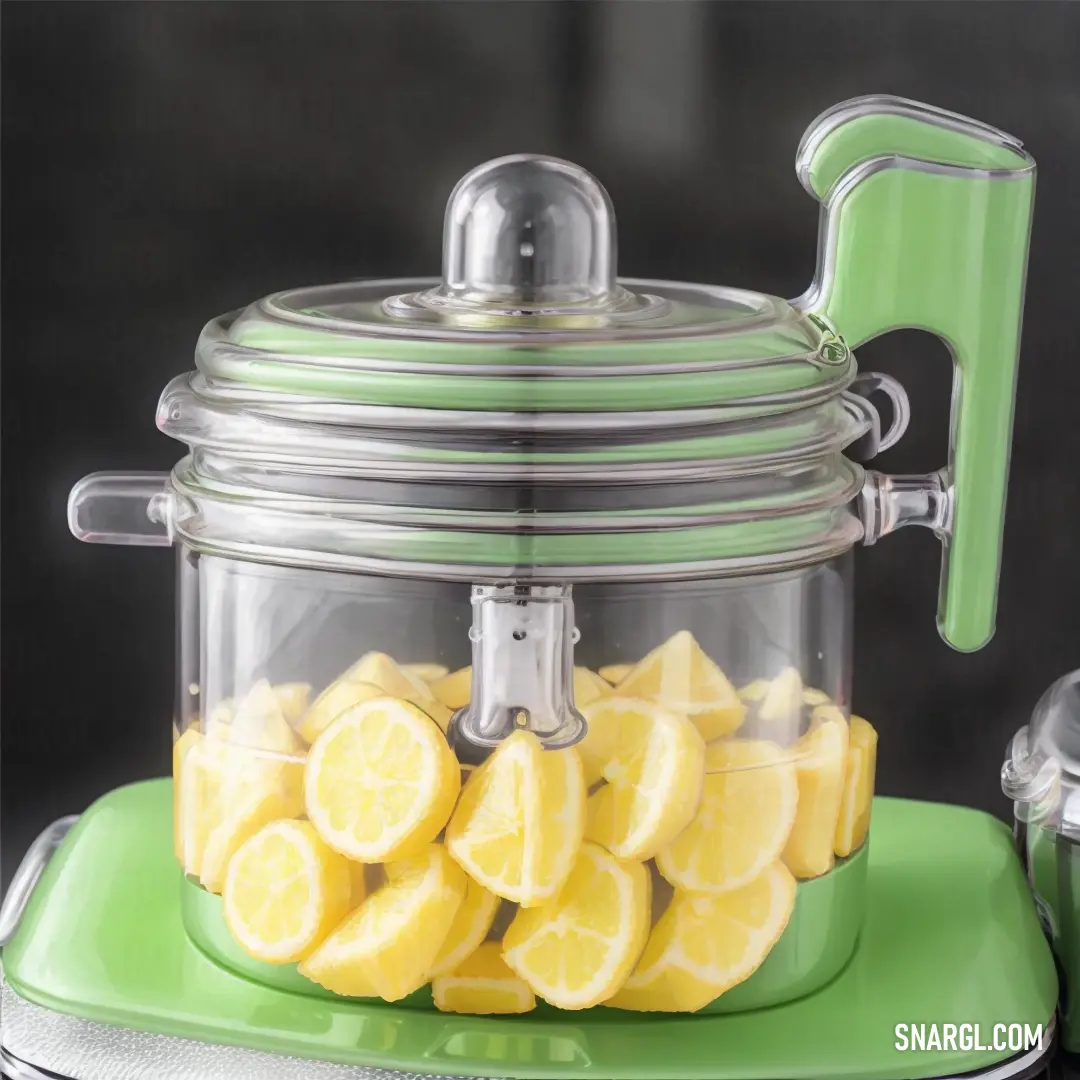 Green and silver food processor with lemons in it and a green lid and a green base