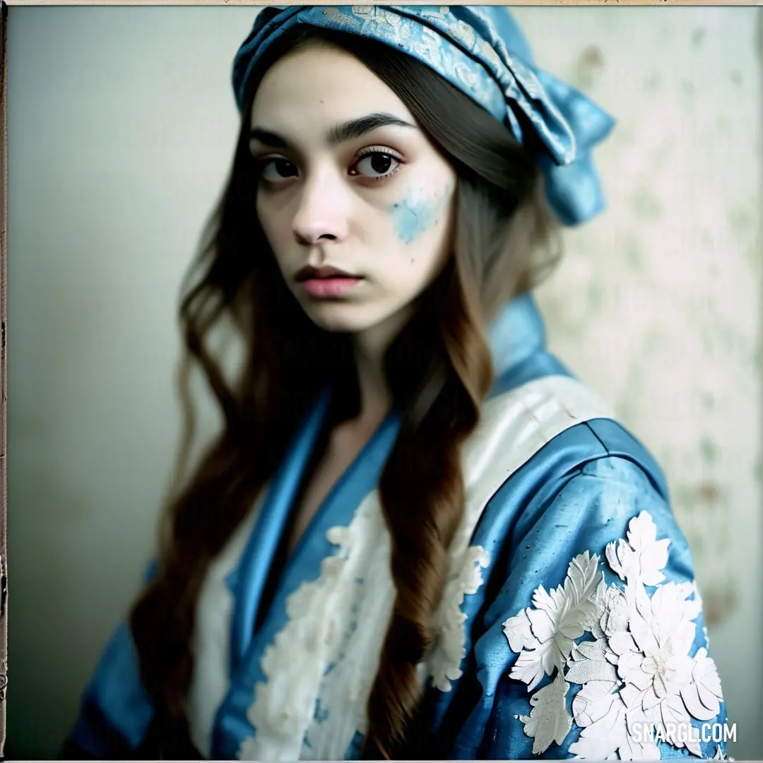 Woman with blue makeup and a blue dress and a flower in her hair