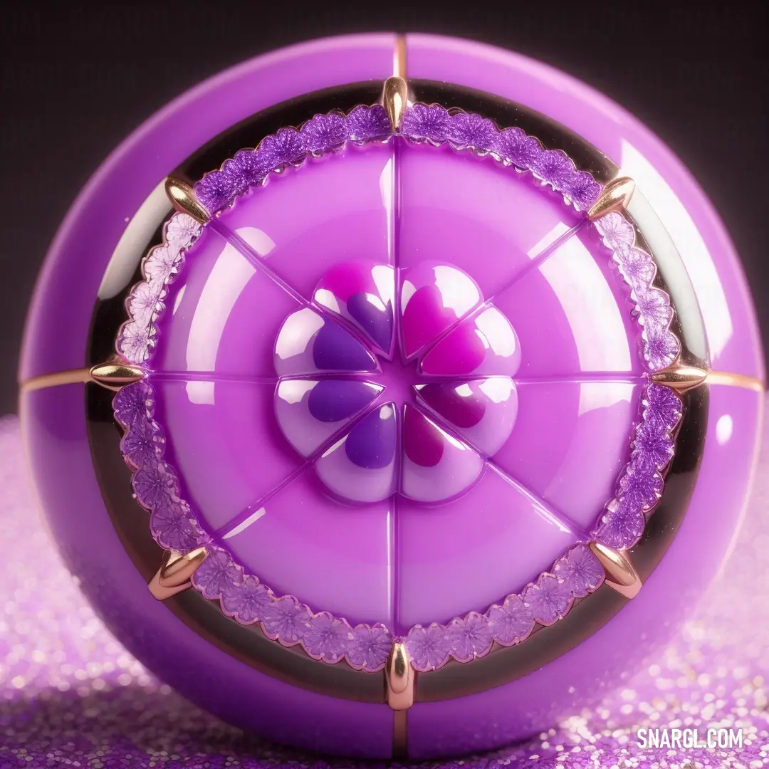 Purple object with a purple center surrounded by gold spikes and beads on a pink surface with a black background