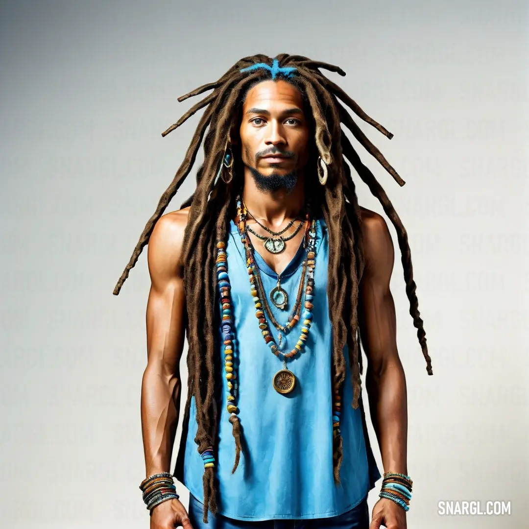 Man with dreadlocks and a blue shirt is standing in front of a white background