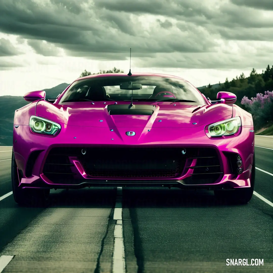 Pink sports car driving down a road under a cloudy sky with trees in the background and a hill in the distance