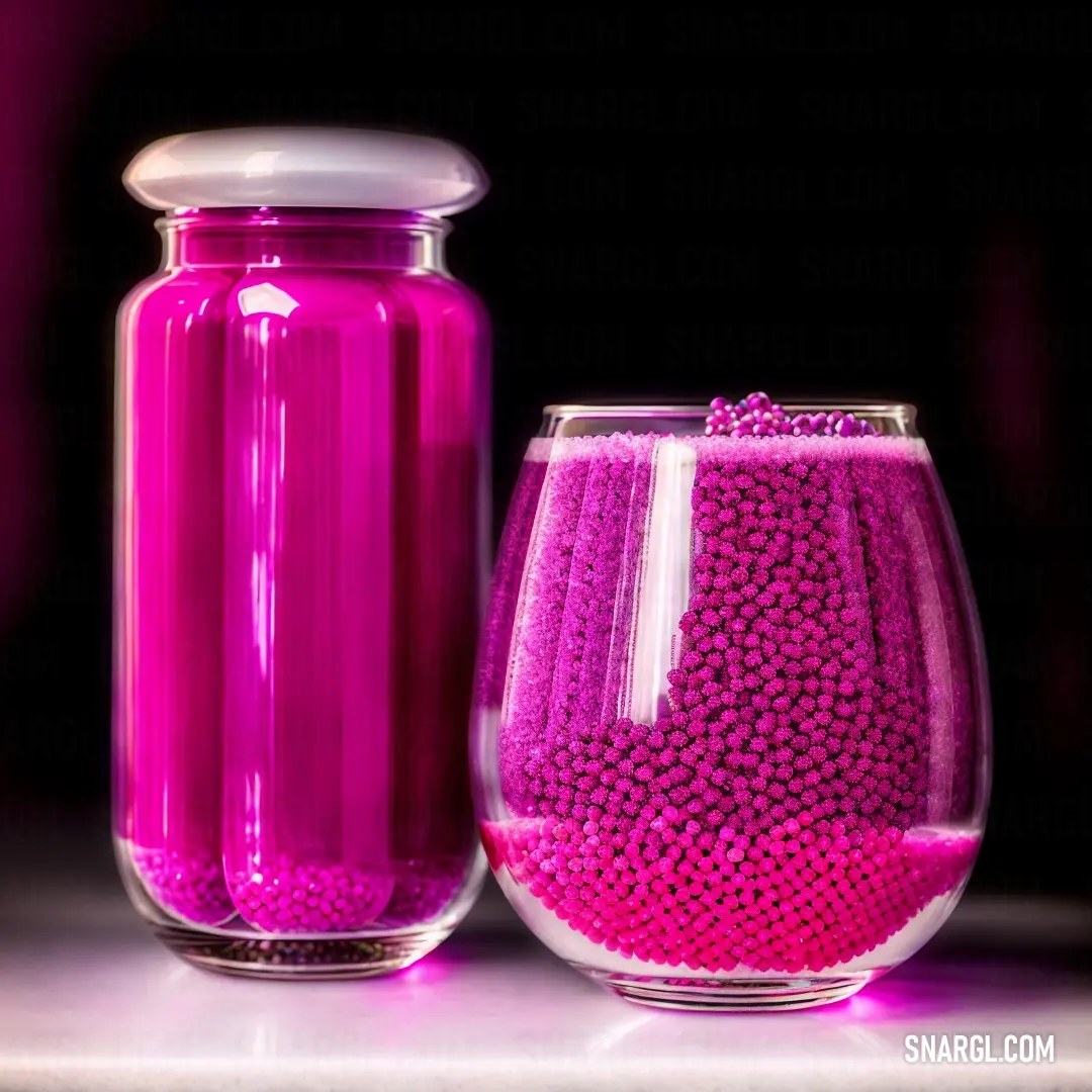 Purple vase and a pink glass on a table with a black background and a pink vase with a white lid