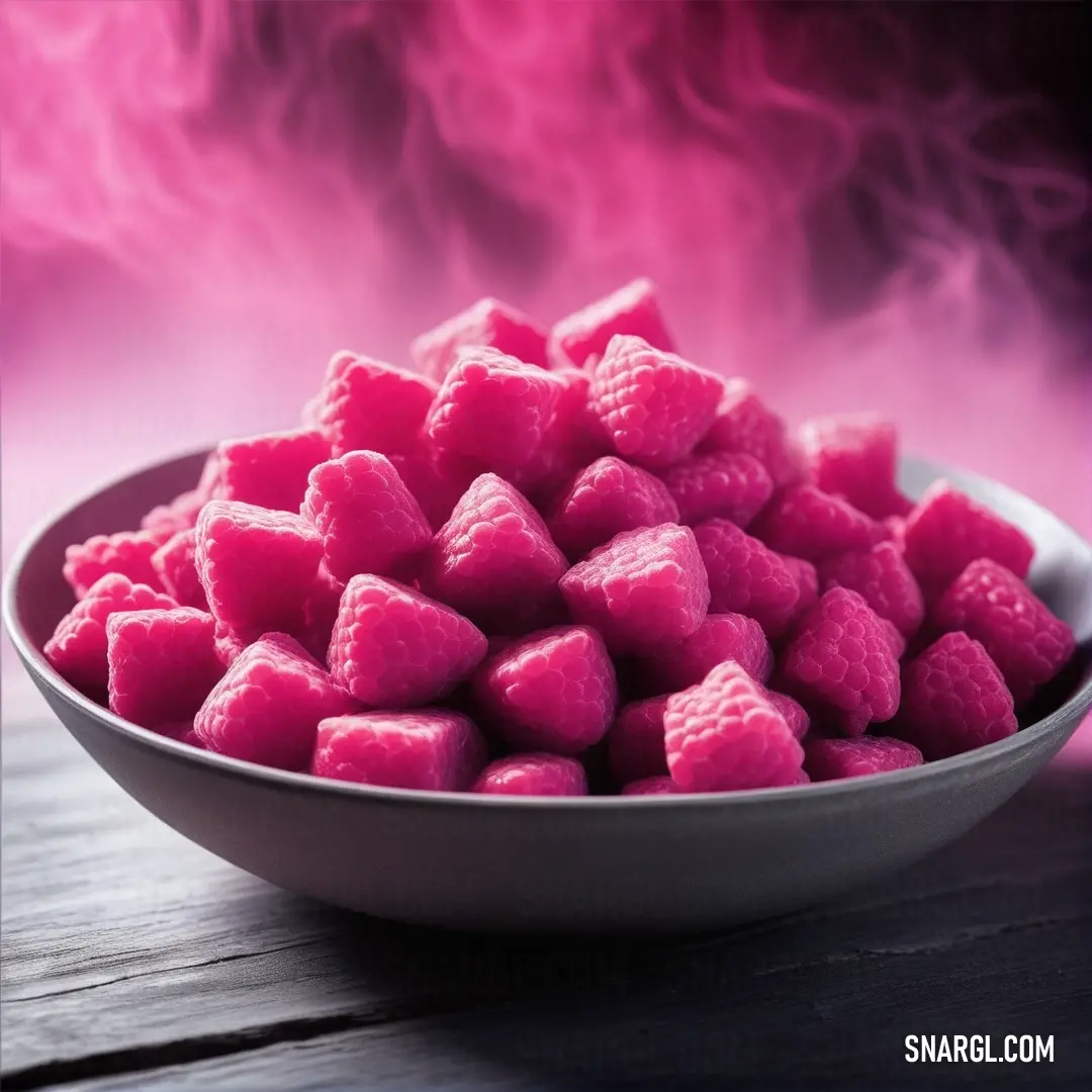 Bowl of pink candy cubes on a table with smoke in the background. Color RGB 255,105,180.