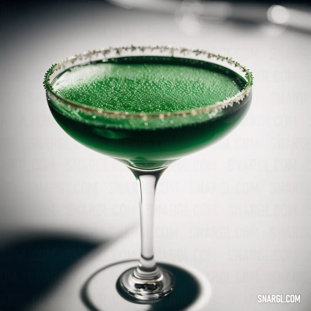 Green drink with a diamond rim in a glass on a table with a white background and a shadow