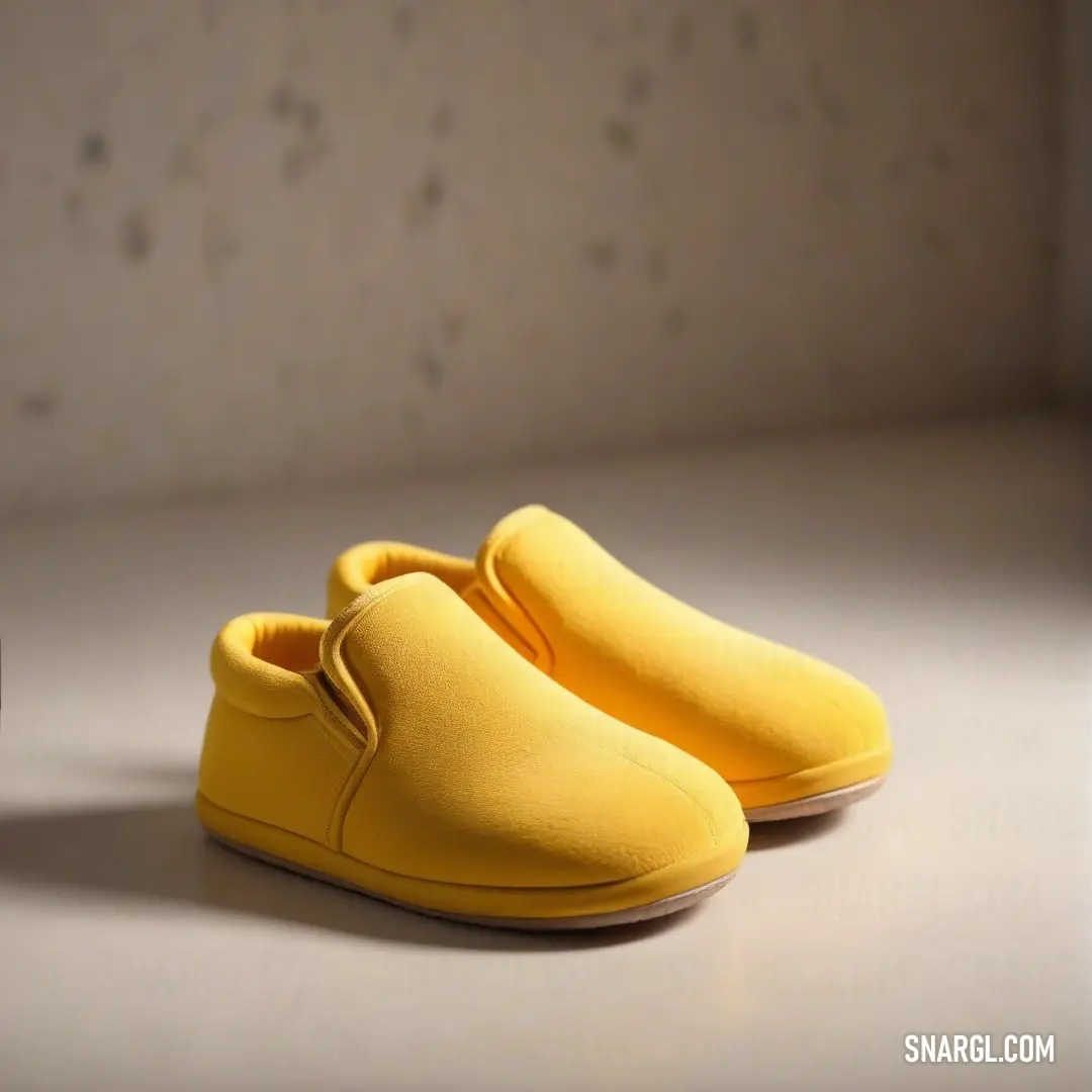 Pair of yellow shoes on top of a table next to a wall and a cup of coffee. Example of CMYK 0,2,63,1 color.