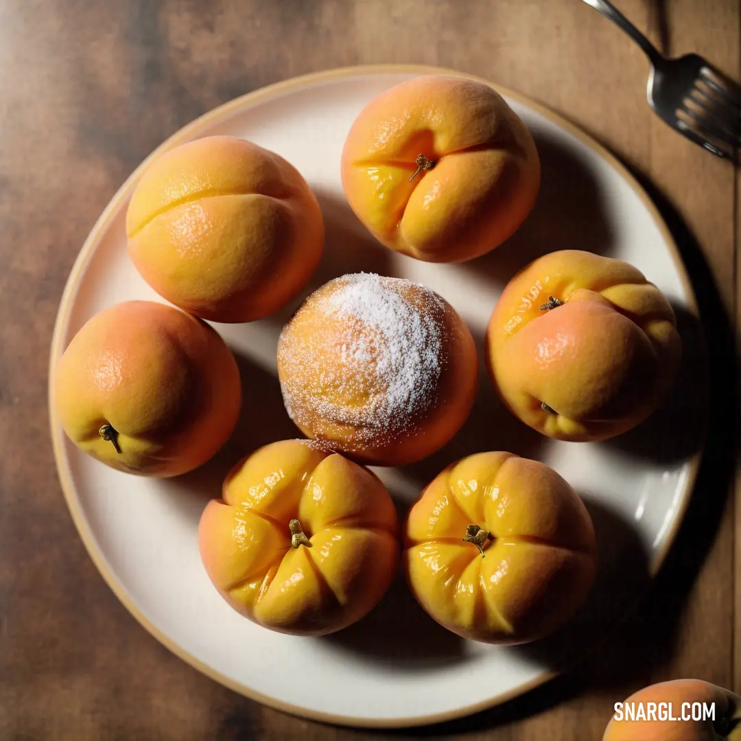 Plate of peaches and powdered sugar on a table with a fork and knife and spoon on it