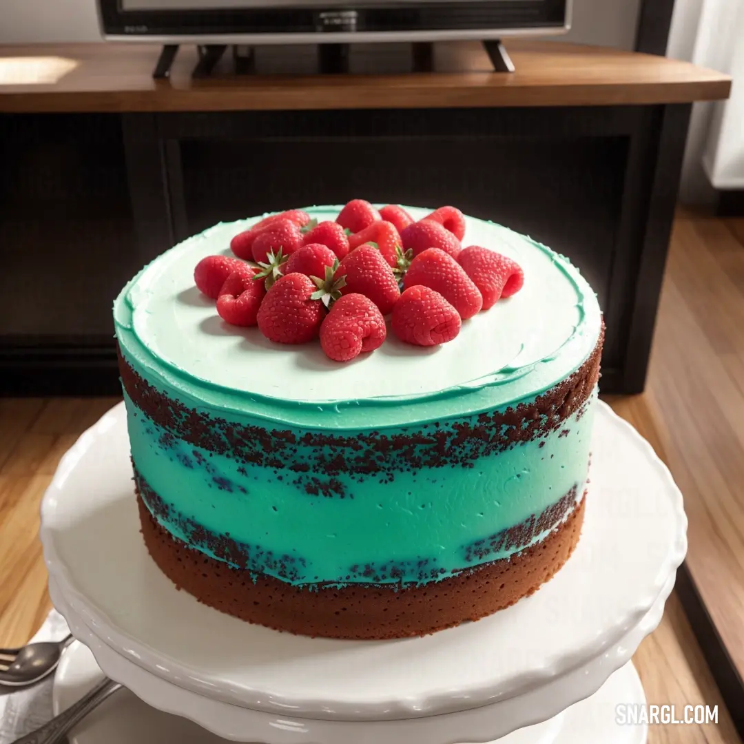 Cake with blue icing and strawberries on top of it on a plate with a tv in the background