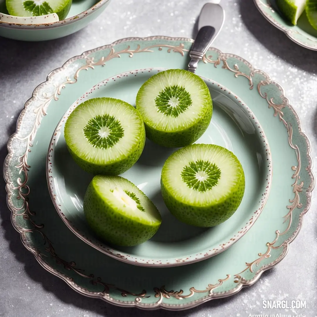 Plate with four pieces of kiwi on it and a spoon on the side of the plate