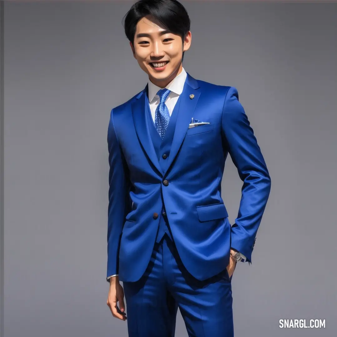 Man in a blue suit and tie smiling at the camera with his hands in his pockets