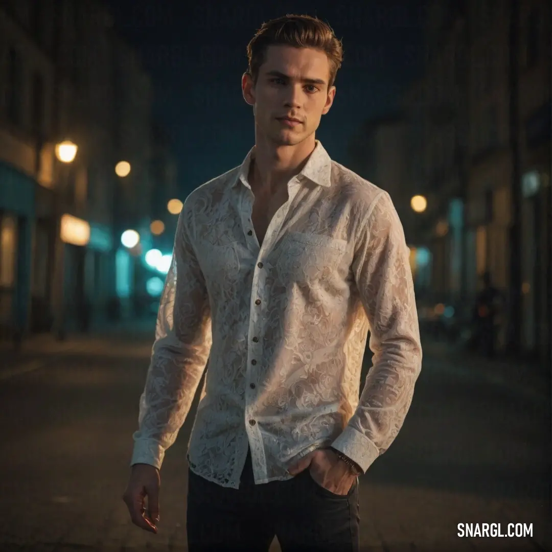 Man standing on a street at night wearing a white shirt and black pants