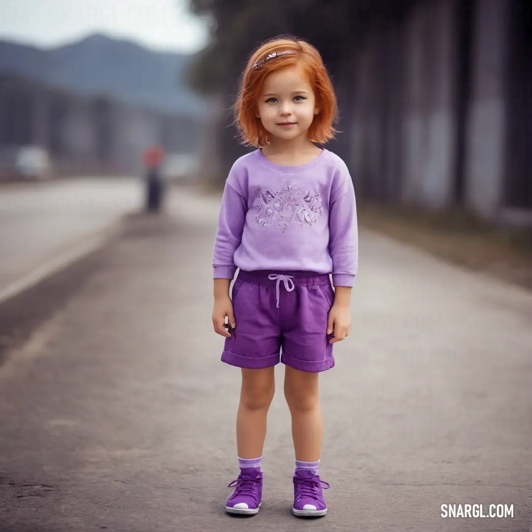 Little girl standing on a street with a purple shirt and purple shorts on. Color CMYK 3,9,0,13.