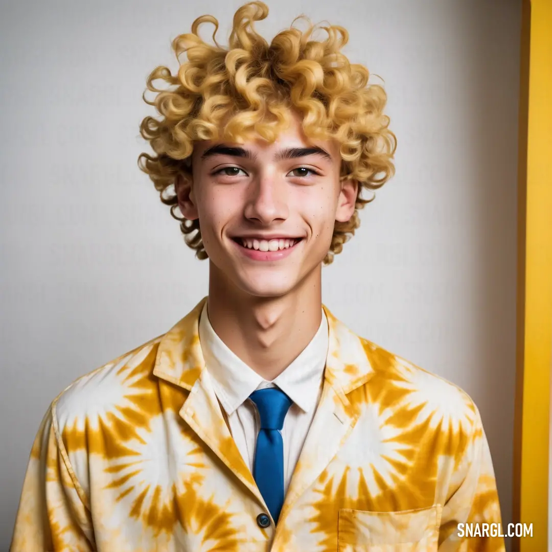 Young man with a tie and a yellow shirt and tie on, smiling at the camera. Color #26619C.