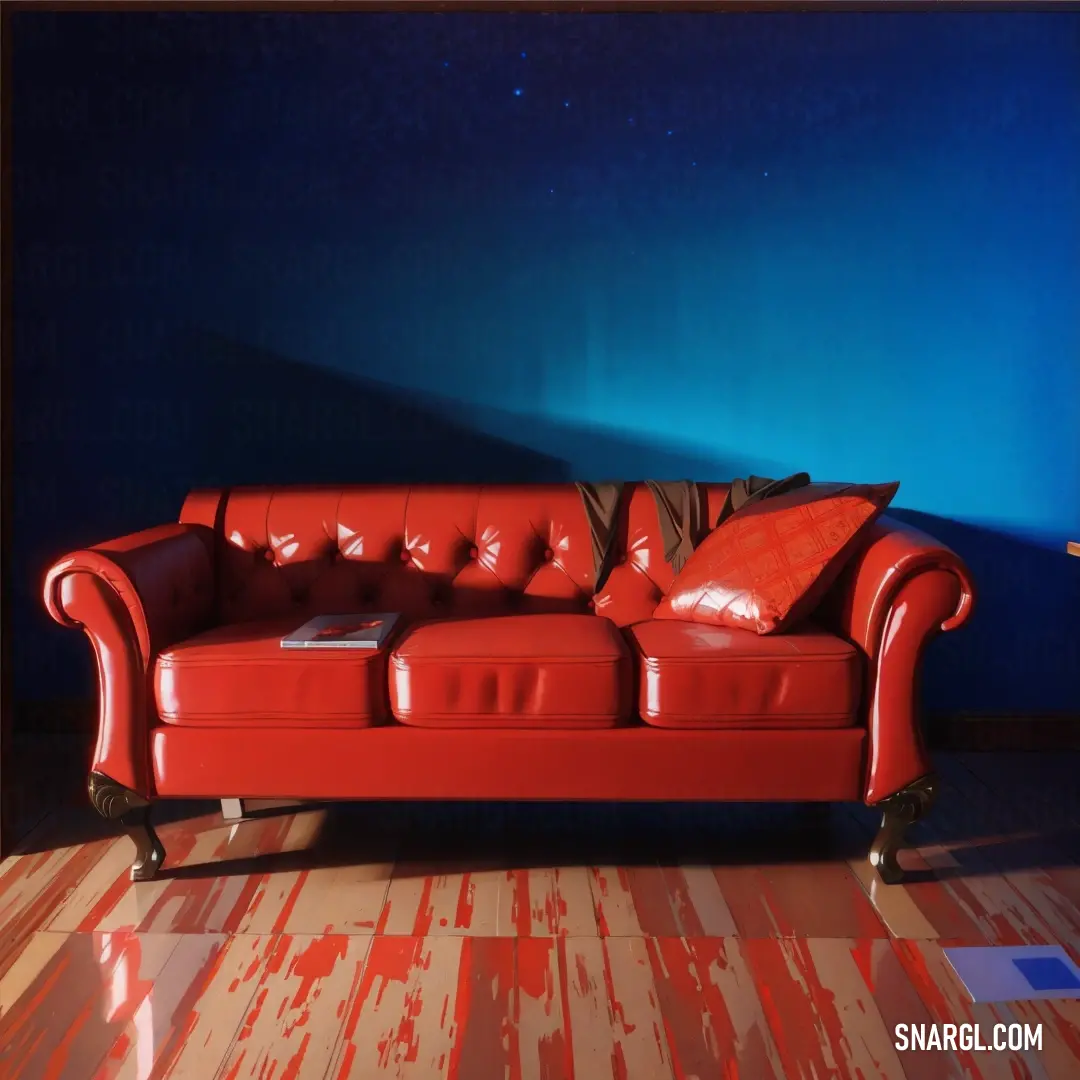 Red couch in a living room next to a blue wall and a lamp on a table with a book