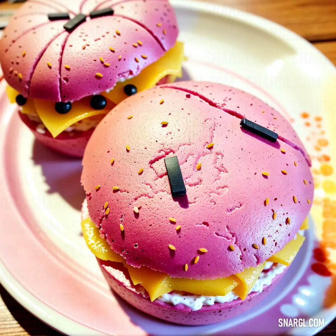 Two pink hamburgers with yellow and black toppings on a plate with a fork and knife on the side