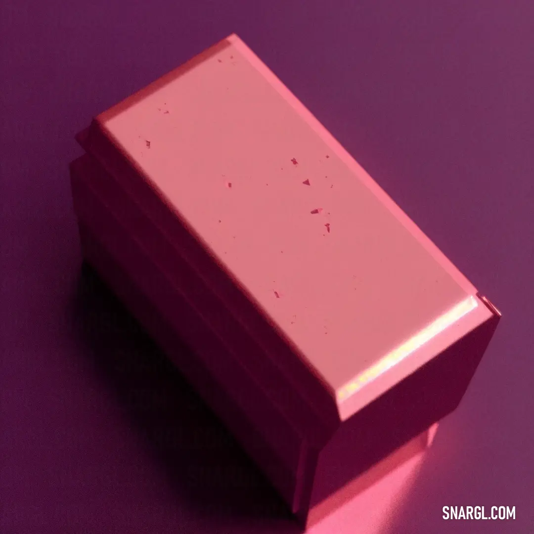 Pink box with a small amount of pink stuff on it's side on a purple surface with a light shining on it