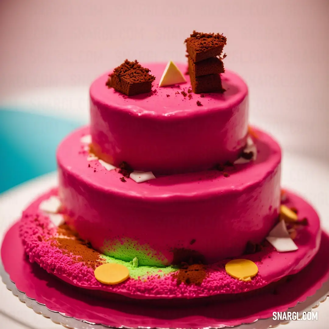 Pink cake with a triangle on top of it on a plate with a blue and yellow tablecloth