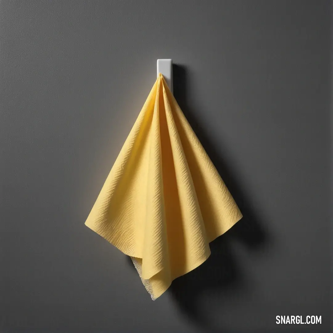 Yellow towel hanging on a hook on a wall with a gray background. Example of Light khaki color.