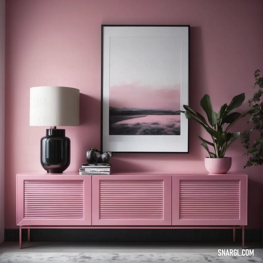 Pink sideboard with a picture on it and a plant on top of it in a room with a pink wall. Color CMYK 0,29,24,0.